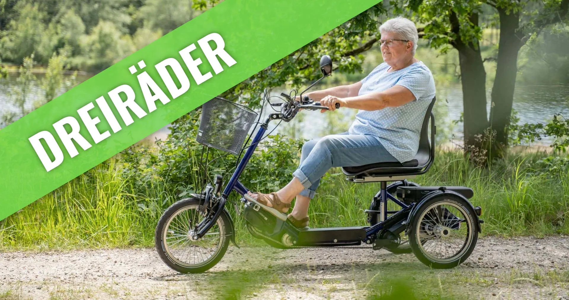 Frau auf einem Erwachsenendreirad auf einem Uferweg